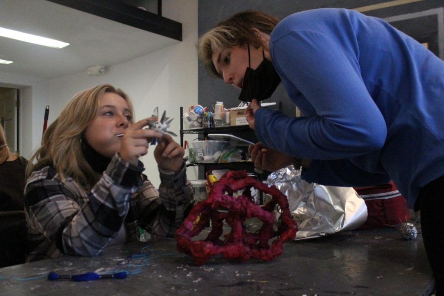 Junior Francis Hoover offers advice to sophomore Hunter Stoffel about her sculpture.