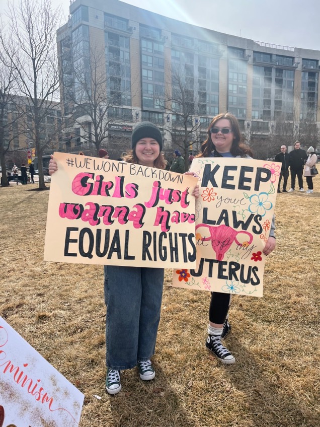 Girl Up members hold signs at Omaha's Women's Day March in Turner Park. Hundreds in the community gathered this day to voice their support for women's rights.