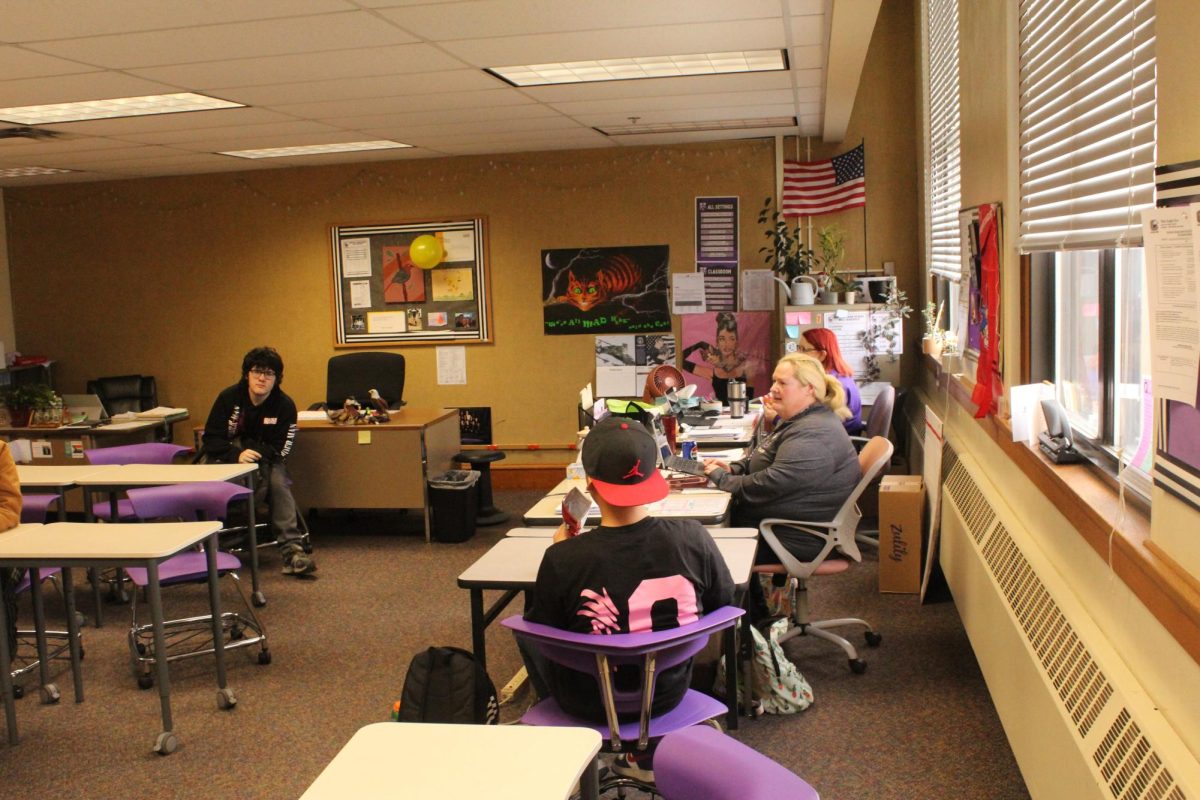 Special Education teacher Abigail Hiller assists students in classroom.