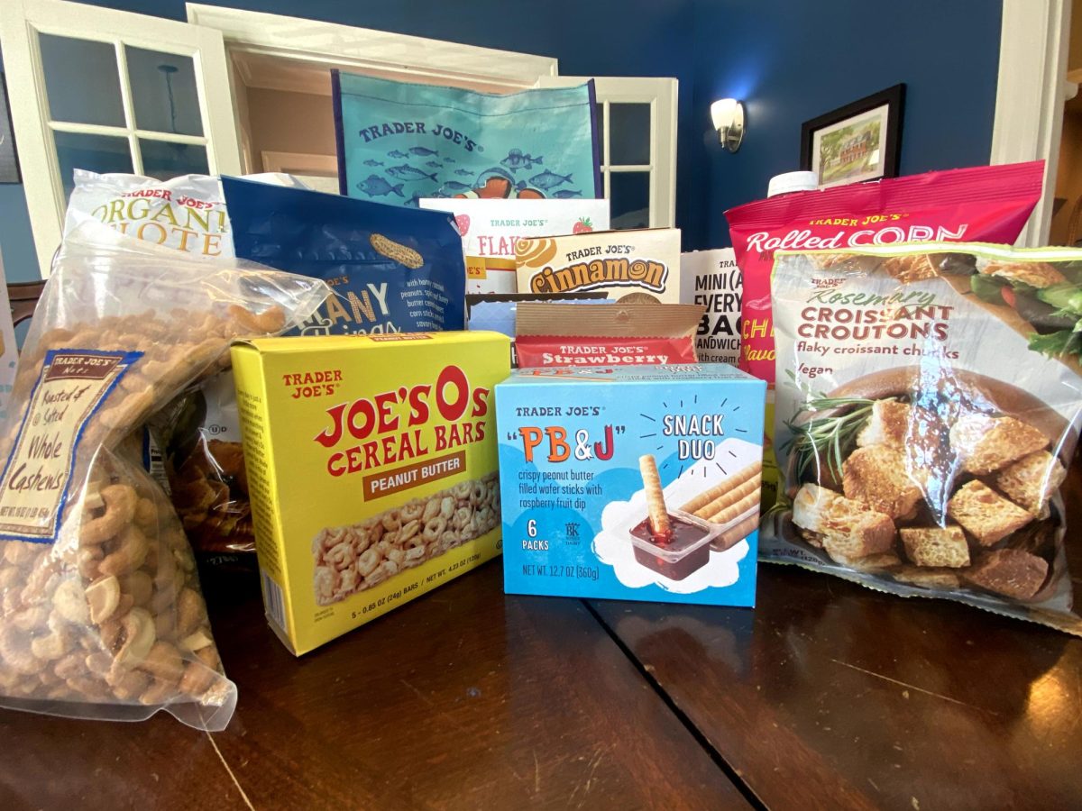 Trader Joes snacks, reviewed for what to try and avoid, sit on a dining room table. 