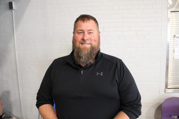 Mr. TerBeest stands in cafeteria for picture