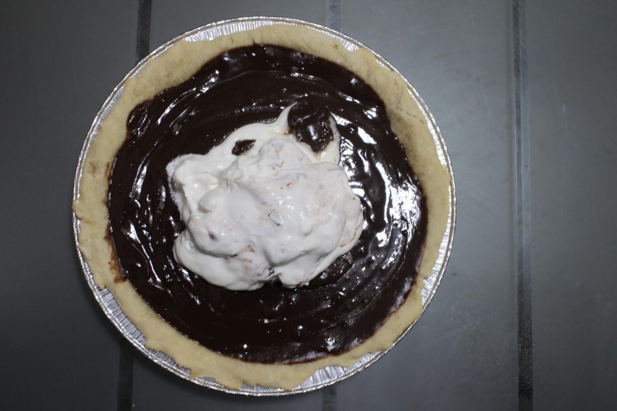 A chocolate pie with cool whip at the center of the pie