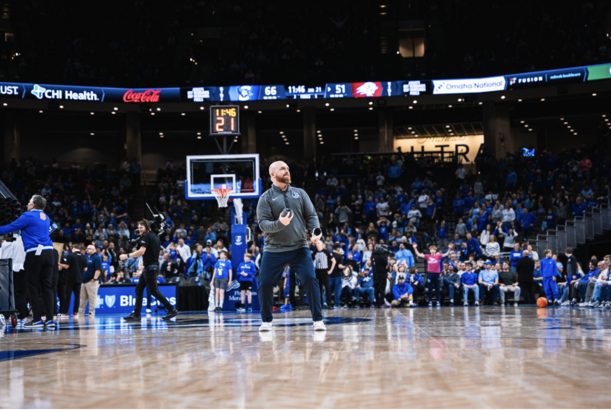 Radio personality Connor Happer throws t-shirts into the crowd at a Creighton basketball game.